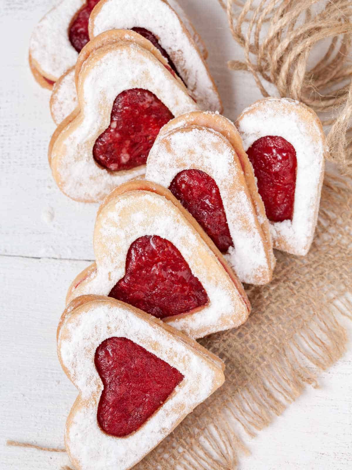 Valentines Day raspberry linzer cookies on a piece of cloth for gift giving.