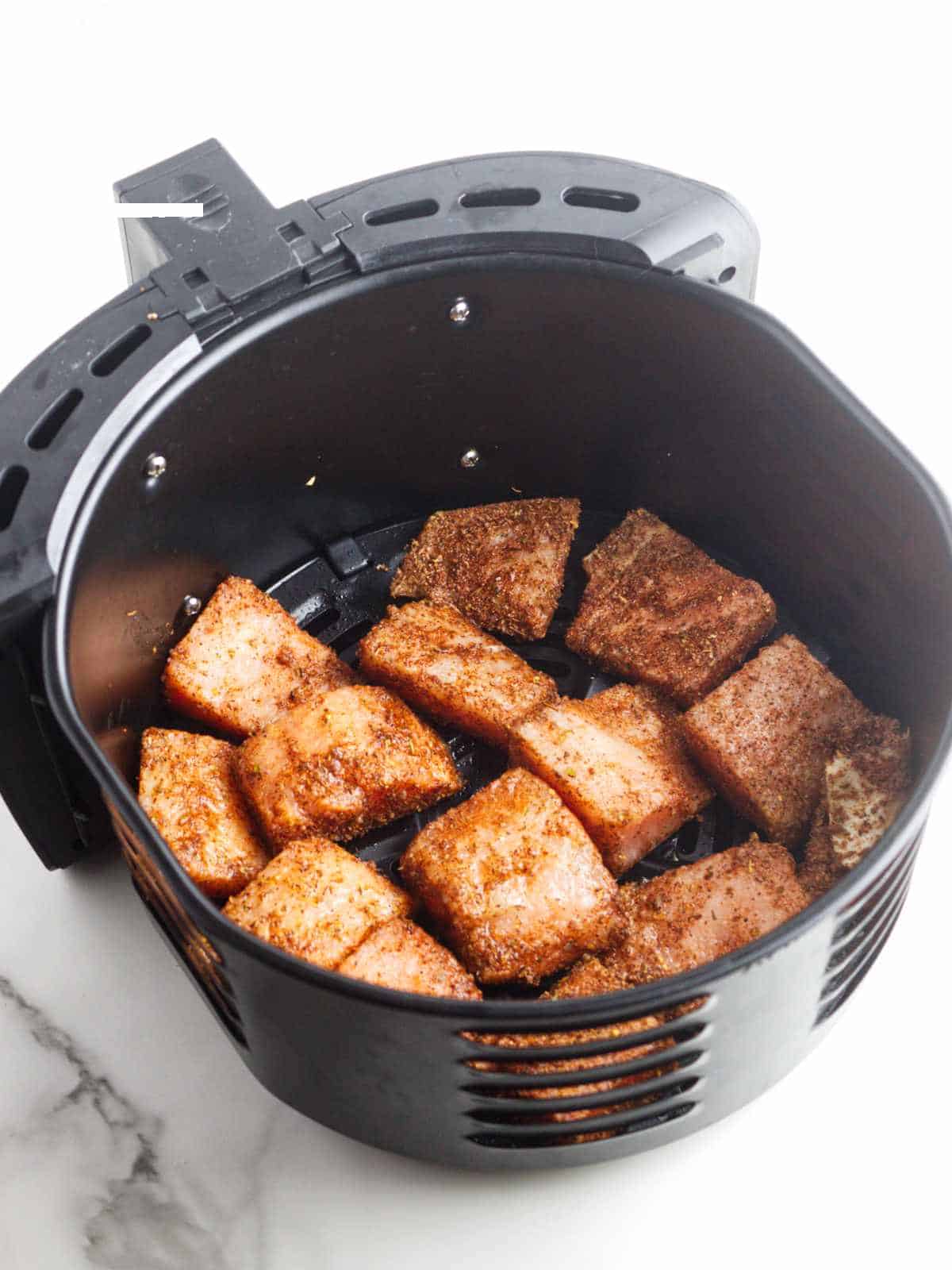 cubes of salmon in an air fryer.