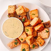 salmon bites on a plate with a dish of tartar sauce.