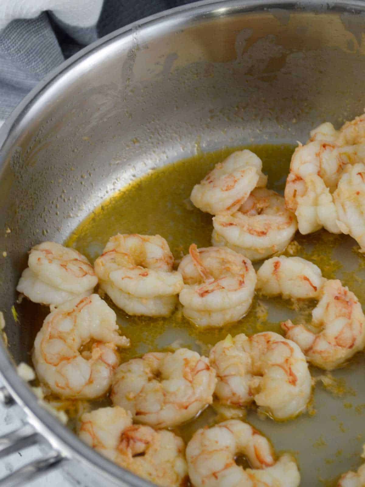 saute pan with shrimp turning pink.