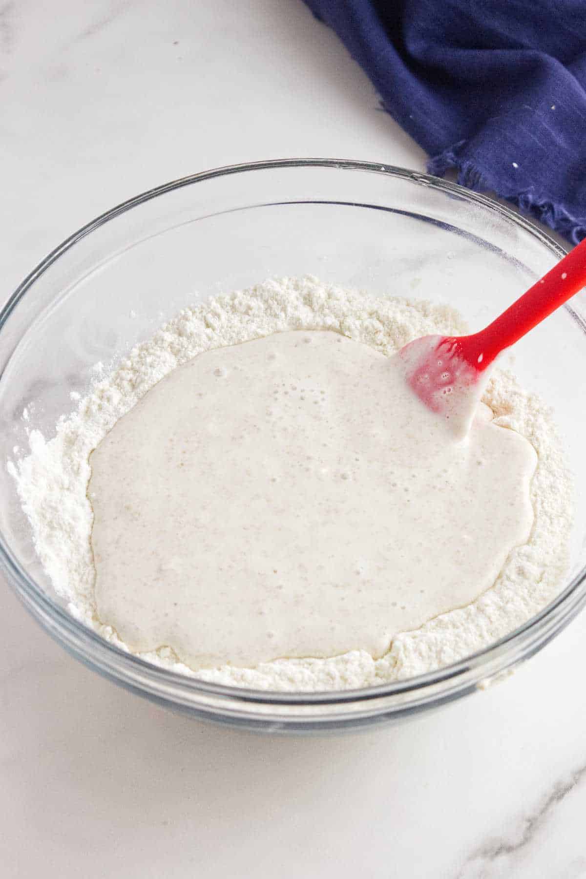 wet ingredients added to a bowl of flour.
