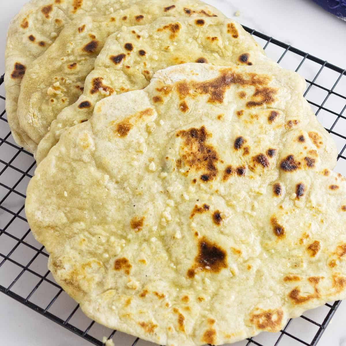 hot naan on a cooling rack.
