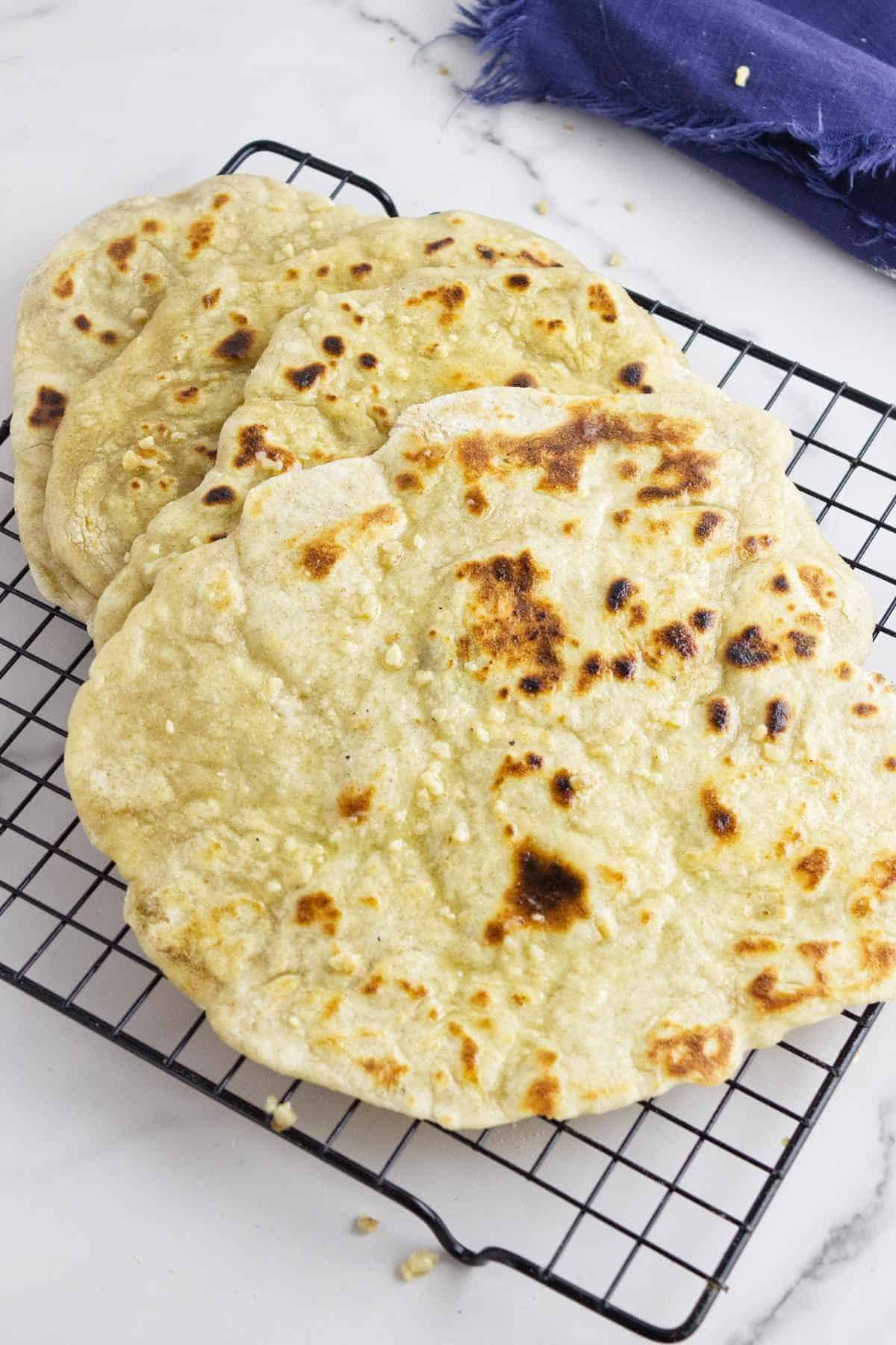 hot sourdough discard naan on a cooling rack.