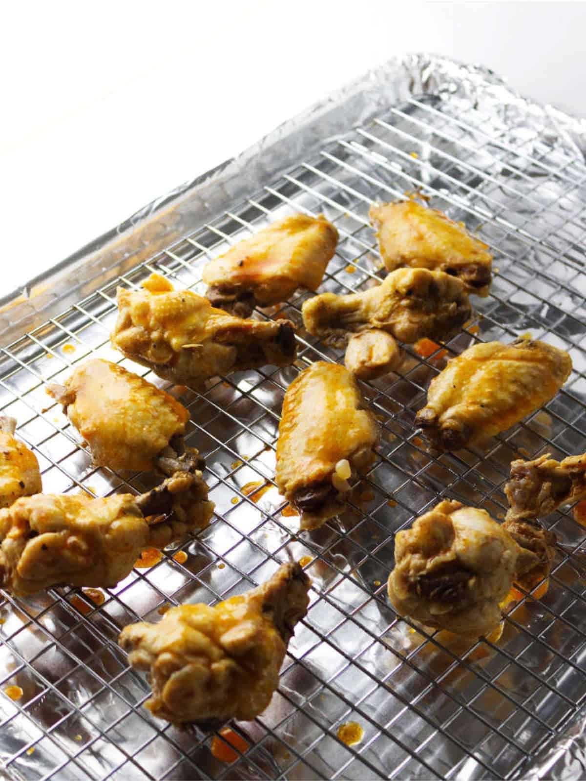 seasoned chicken on a rack on a baking sheet.