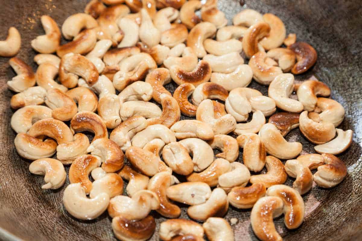 Closeup of roasted cashew on frying pan.