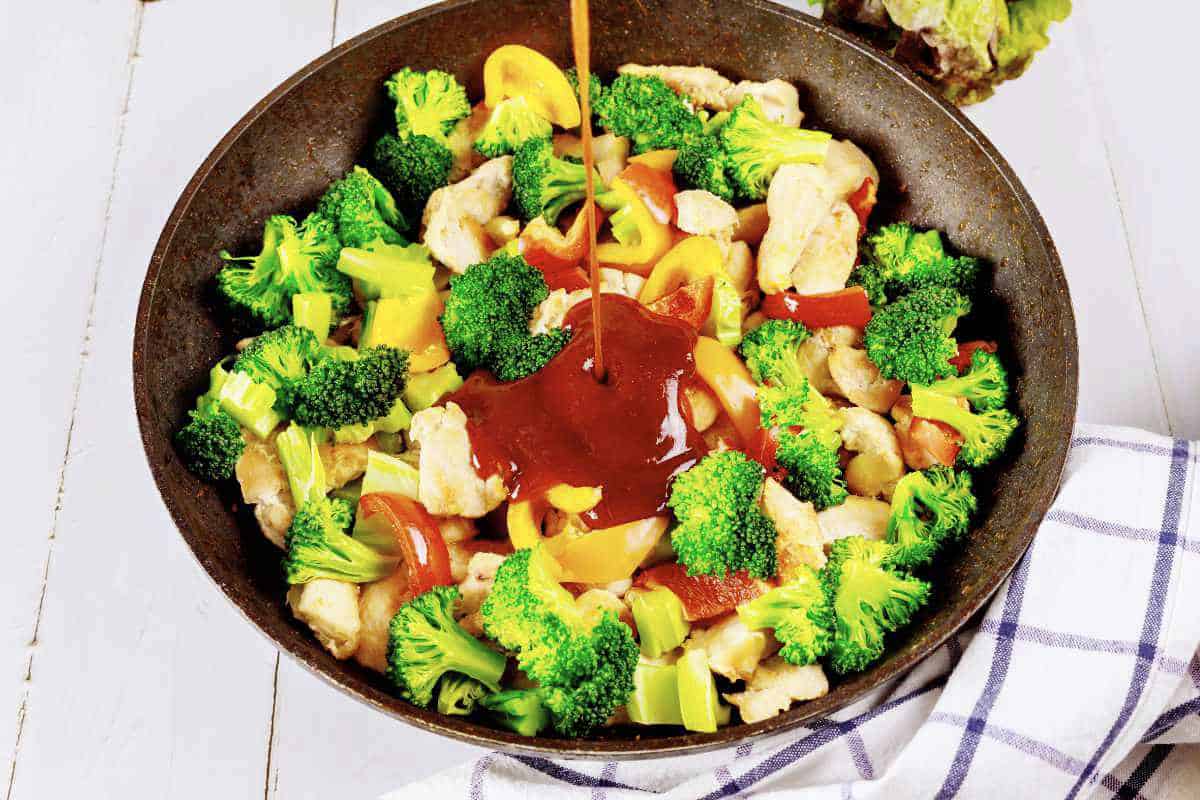 wok full of broccoli, chicken, bell peppers, and cashews.