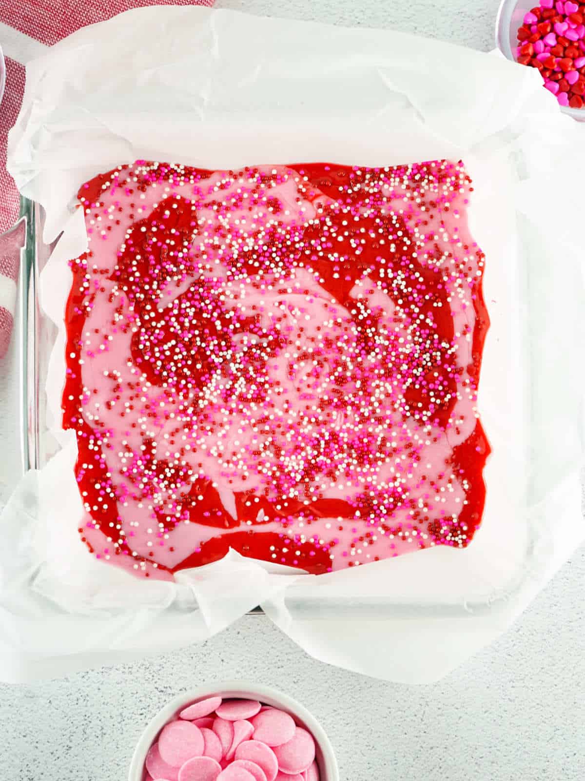 baking pan of strawberry fudge sprinkled with Valentines themed sprinkles.