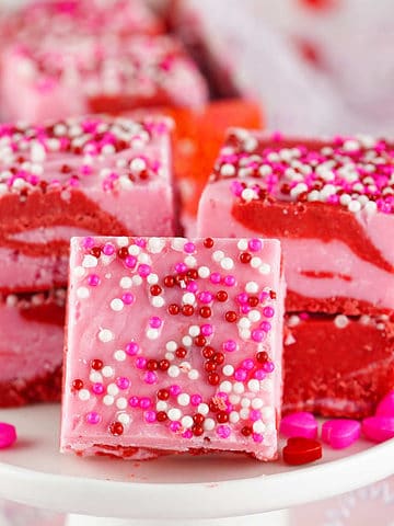 squares of pink and red strawberry fudge placed on a plate.