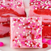 squares of pink and red strawberry fudge placed on a plate.