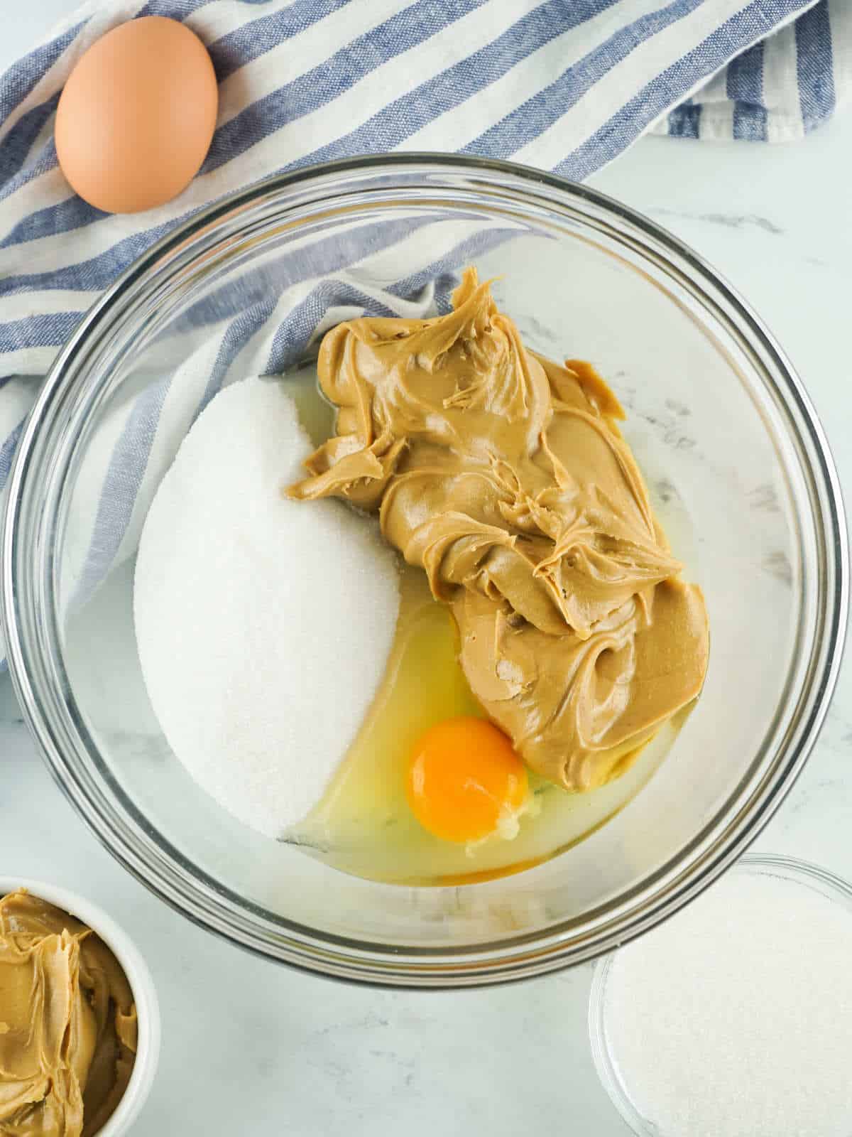 peanut butter, sugar, and egg in a bowl.