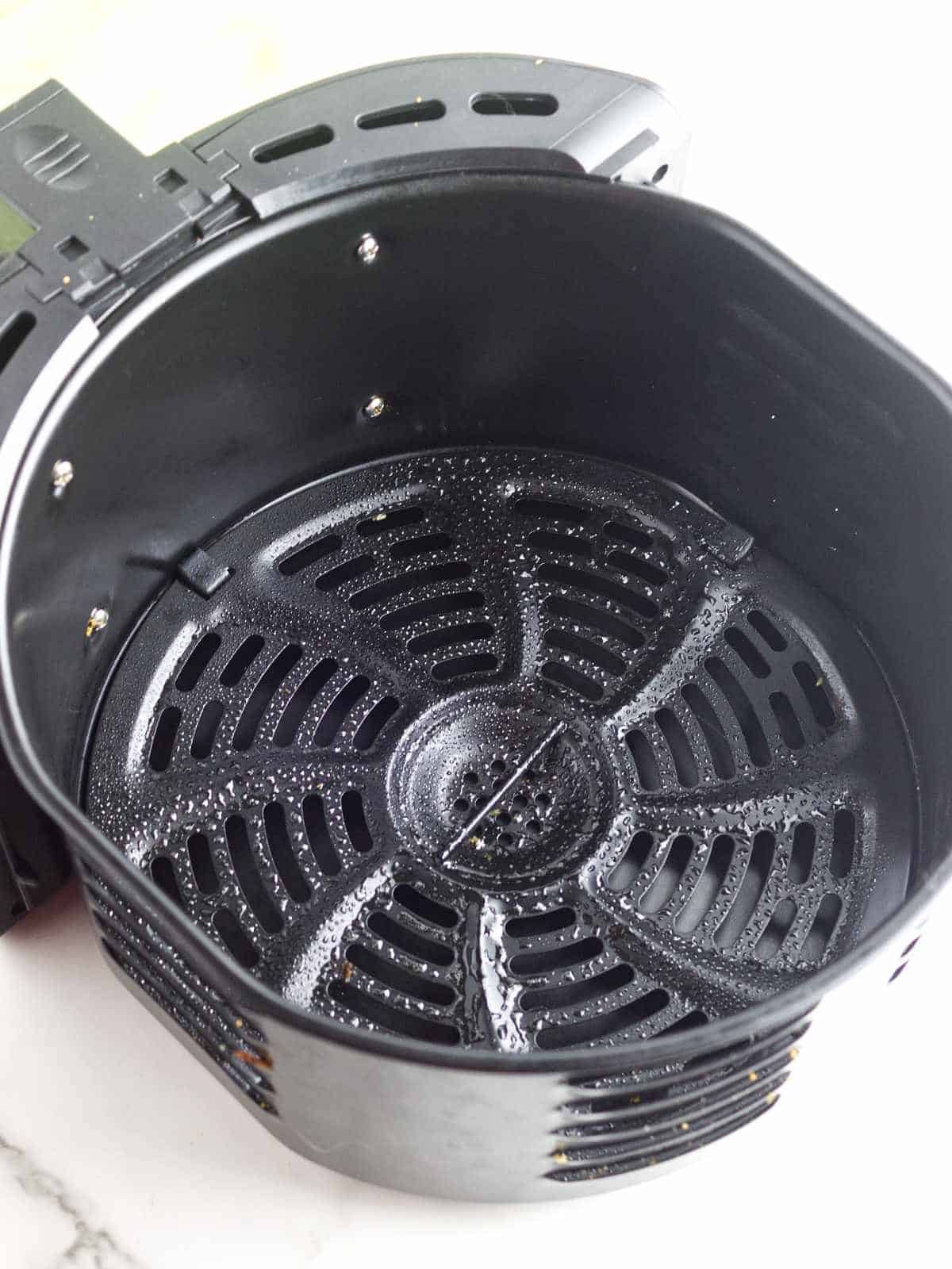air fryer basket with non stick spray grill inside of basket.