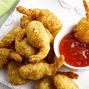 cooked frozen coconut shrimp on a platter with thai chili sauce.