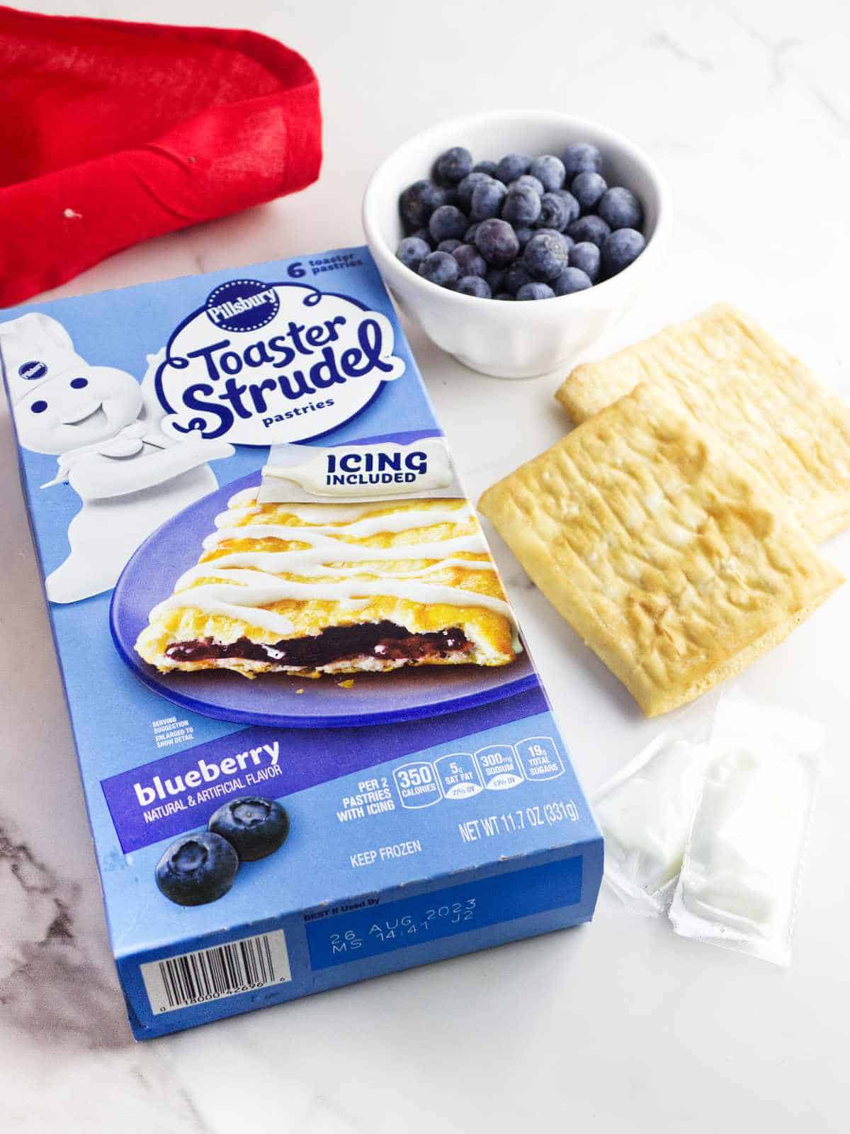 Pillsbury blueberry toaster strudels, icing, and blueberries.