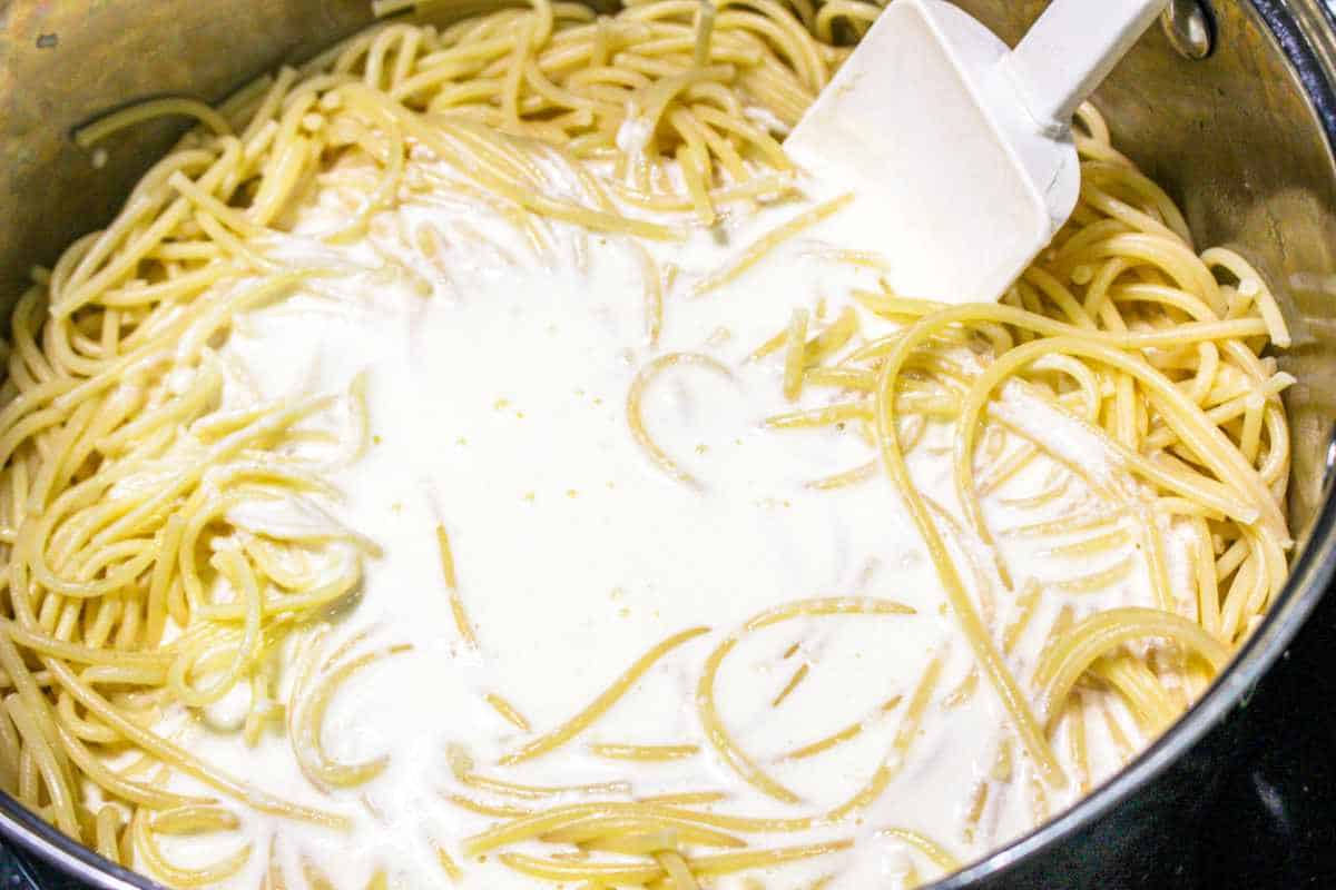 Alfredo sauce mixed with cooked spaghetti noodles.