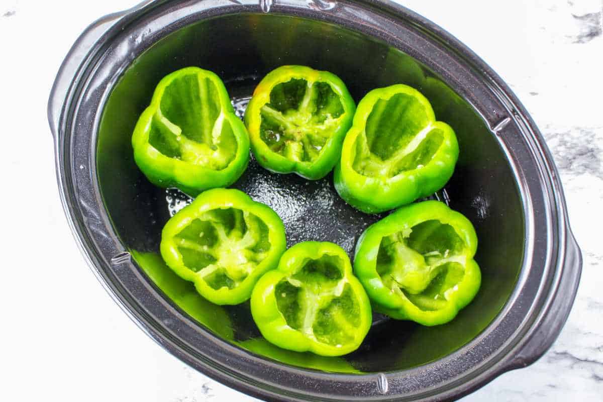 raw green bell peppers in a crockpot.