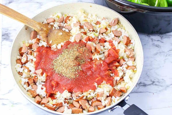 spices and herbs added to skillet of sausage, rice, and onions.