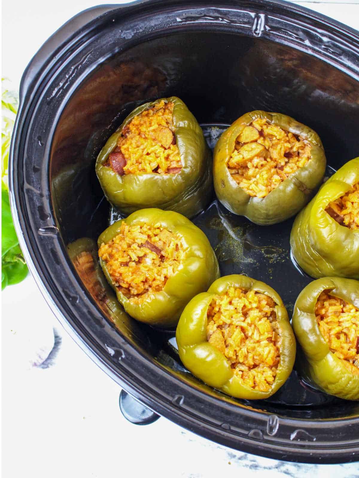 slow cooker with finished sausage stuffed peppers.