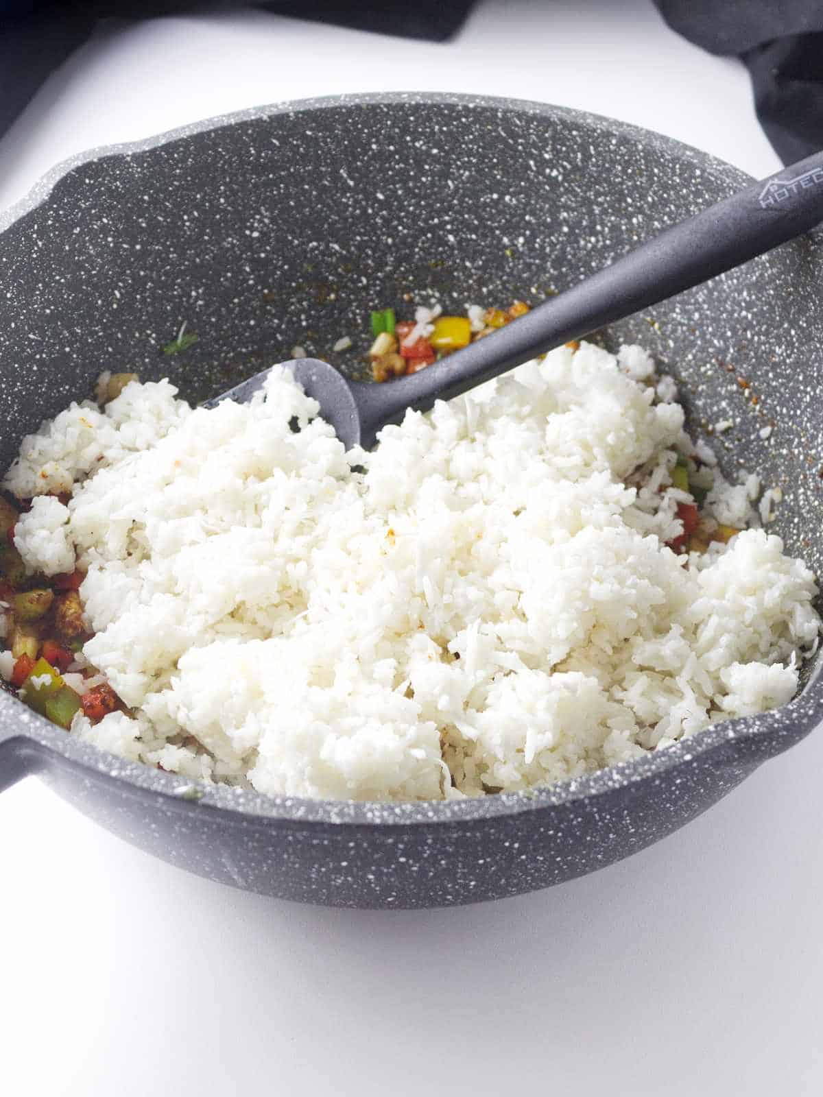 cooked rice added to a skillet.