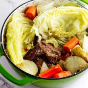 Dutch oven filled with cooked corned beef and cabbage.
