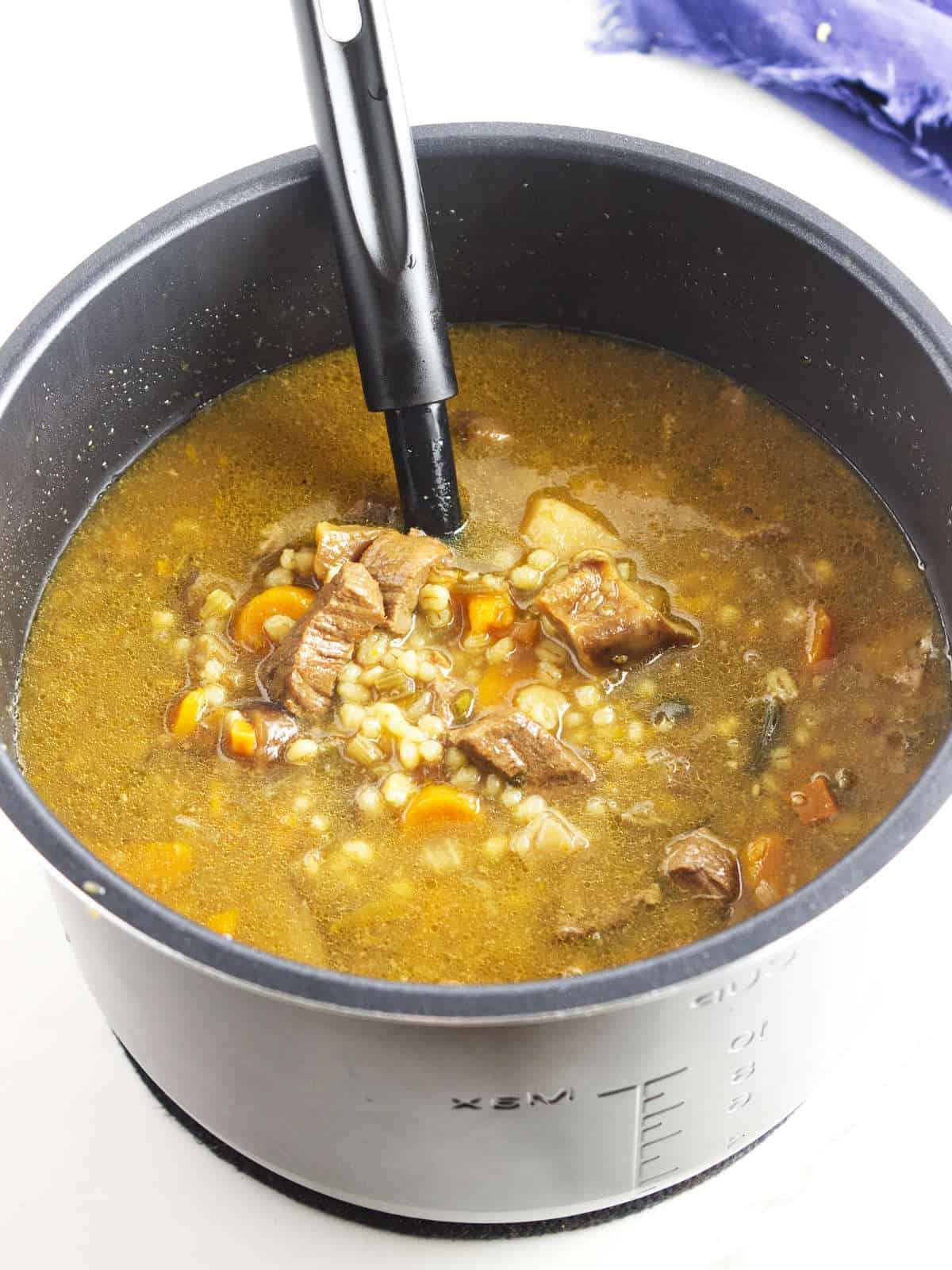 an instant pot full of finished beef and barley soup.
