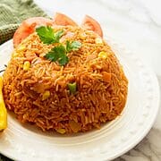 Jollof rice Ghanaian style, molded in a small bowl on a plate.