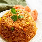 Jollof rice Ghanaian style, molded in a small bowl on a plate.
