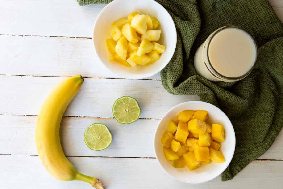 ingredients for making a mango and pineapple with banana smoothie.