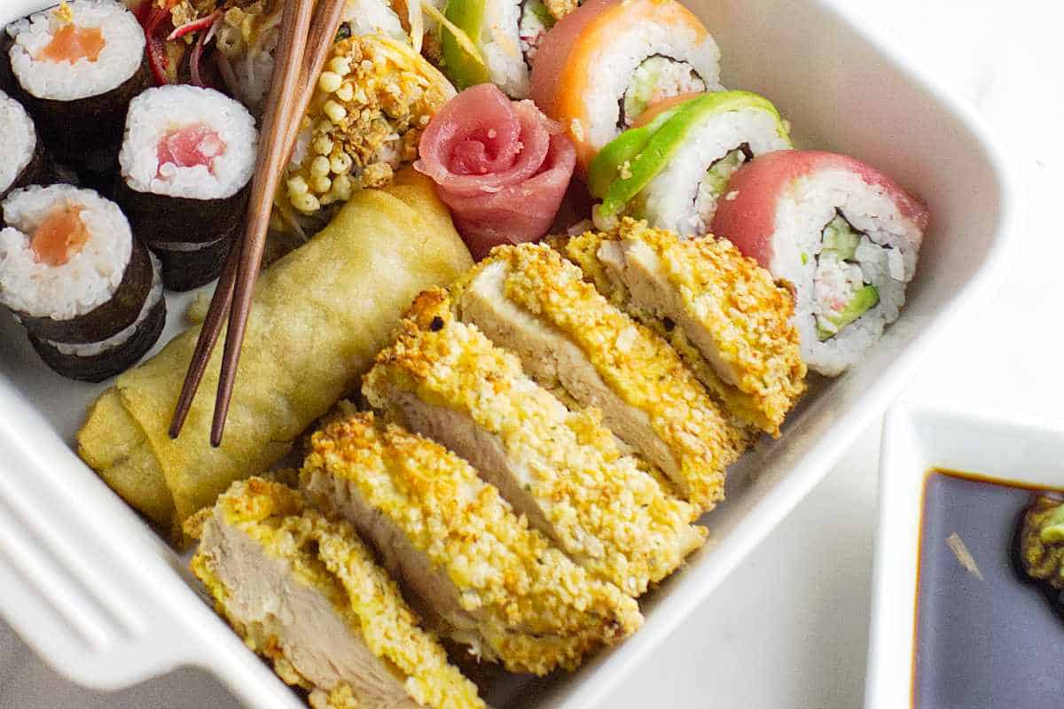 Bento box with chicken katsu slice with a california roll.