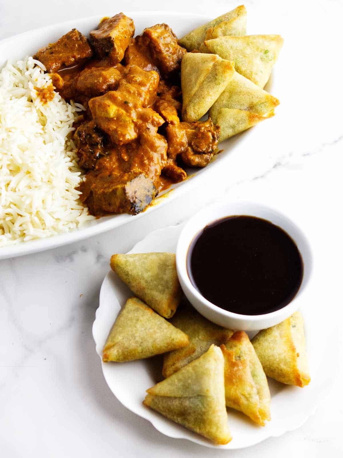 air fried appetizers with dip and platter of rice and curry.