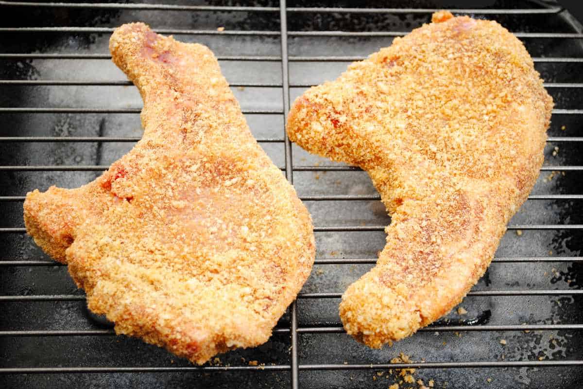two raw breaded pork chops for air frying.