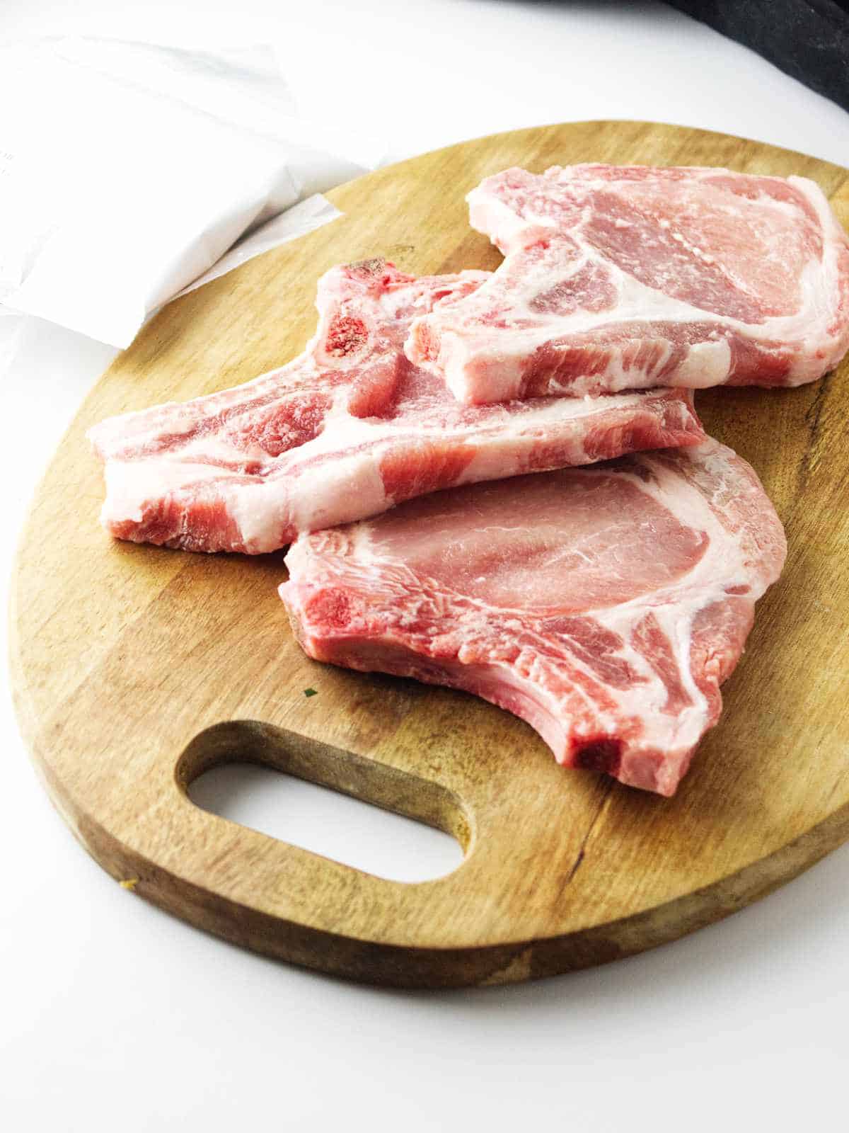 seasoning raw pork chops.