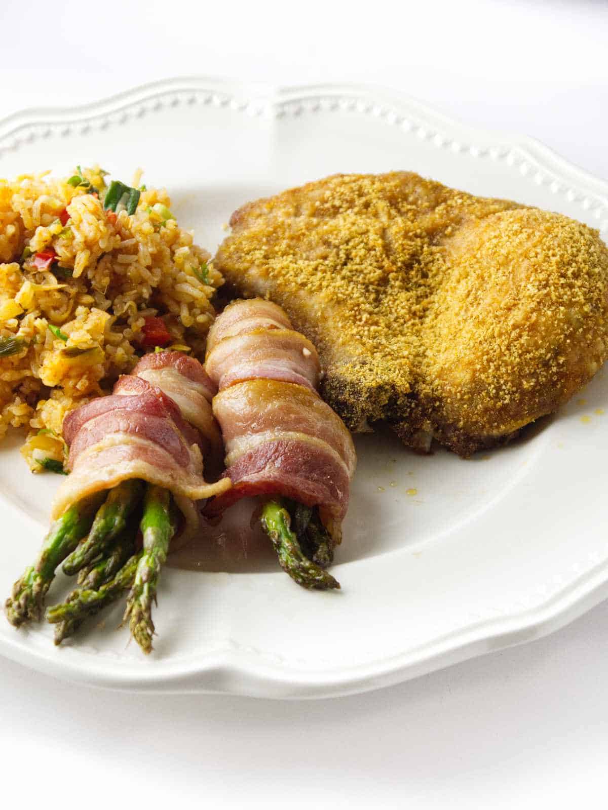 air fried pork chop with bacon wrapped asparagus and chimichurri rice.