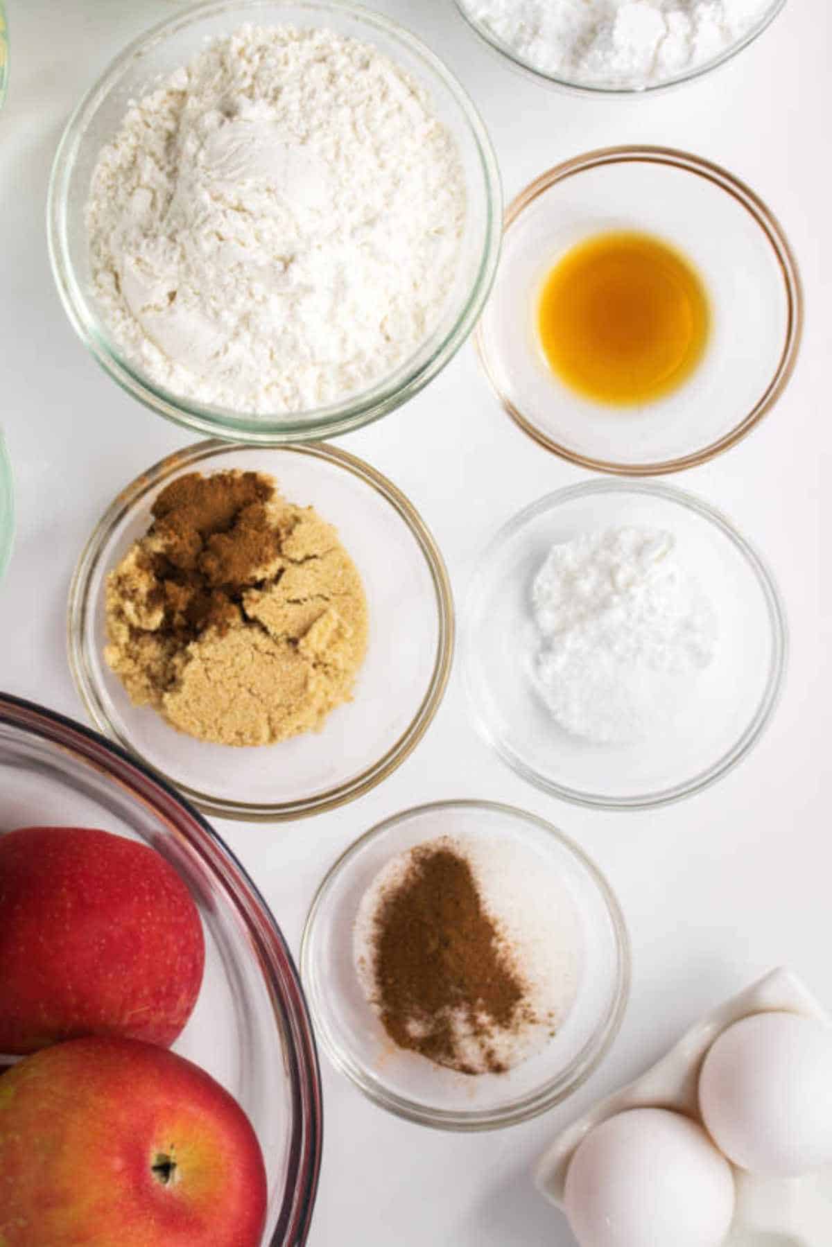 bowls of ingredients for making an apple cake.