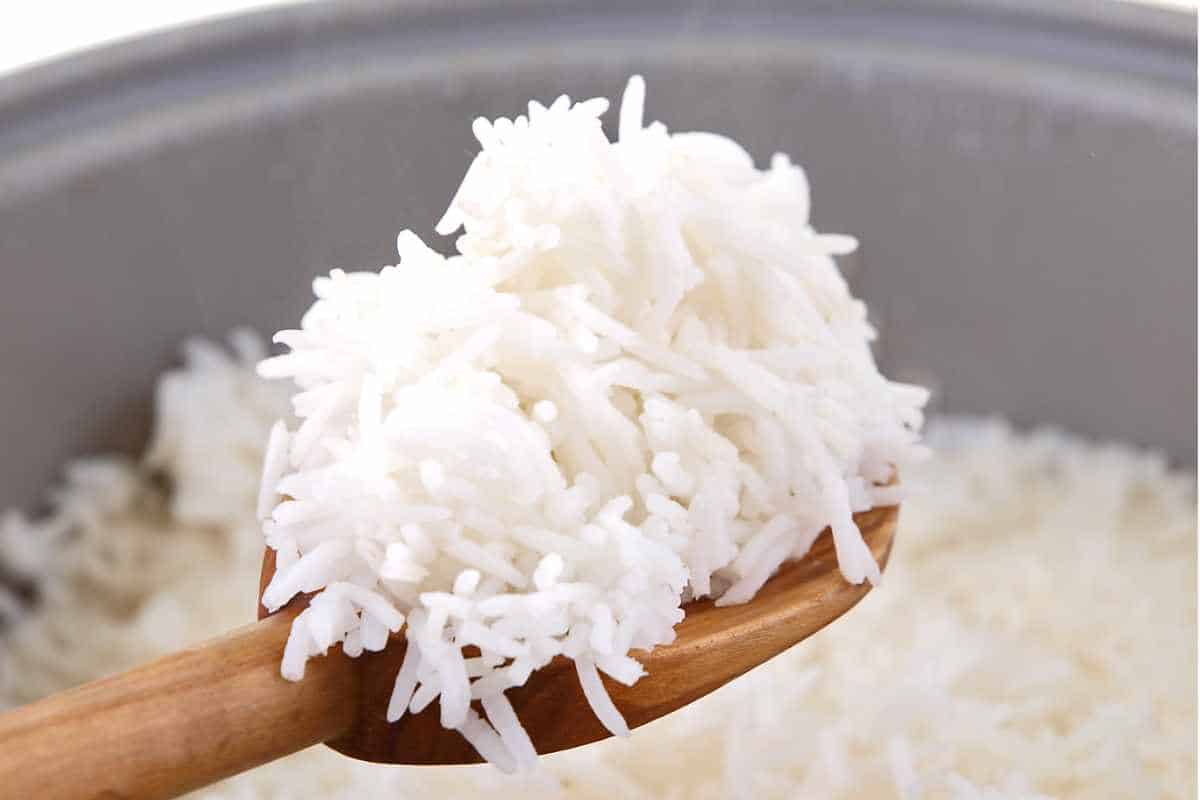 fluffy Aroma Rice Cooker rice on a wooden spoon.