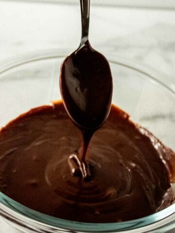spoonful of chocolate ganache dribbling into a bowl.
