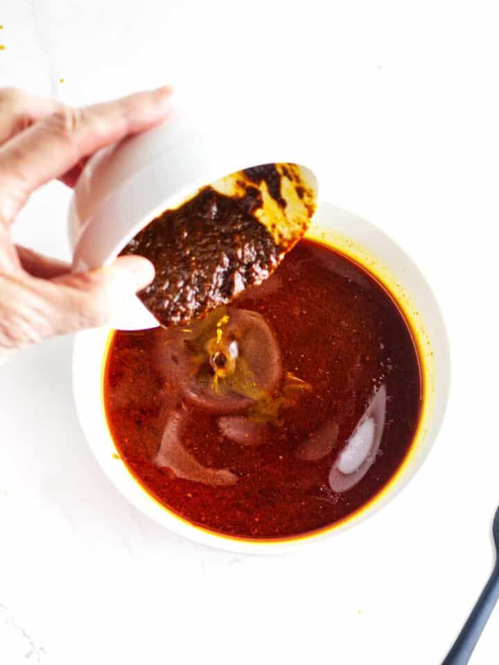 Chile paste added to birria consome before simmering.