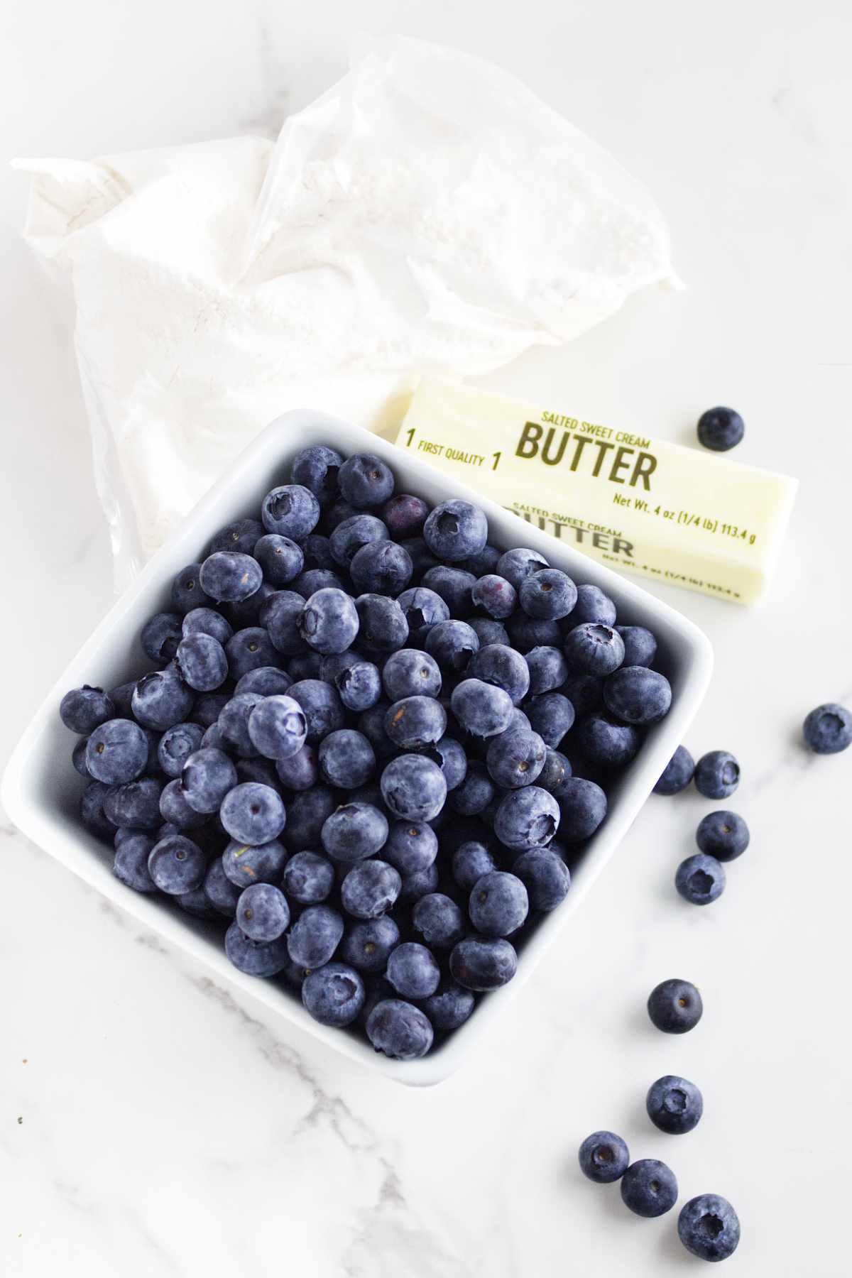 carton of fresh blueberries, stick of butter, and a cake mix.