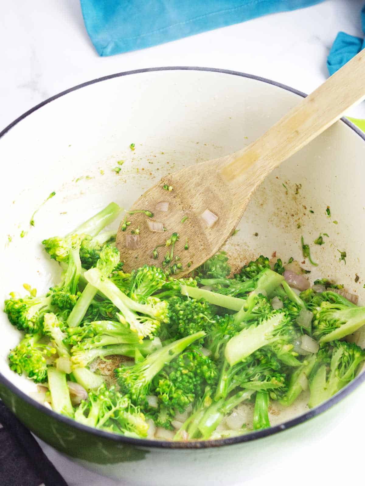 broccoli being sauteed in a saucepan.