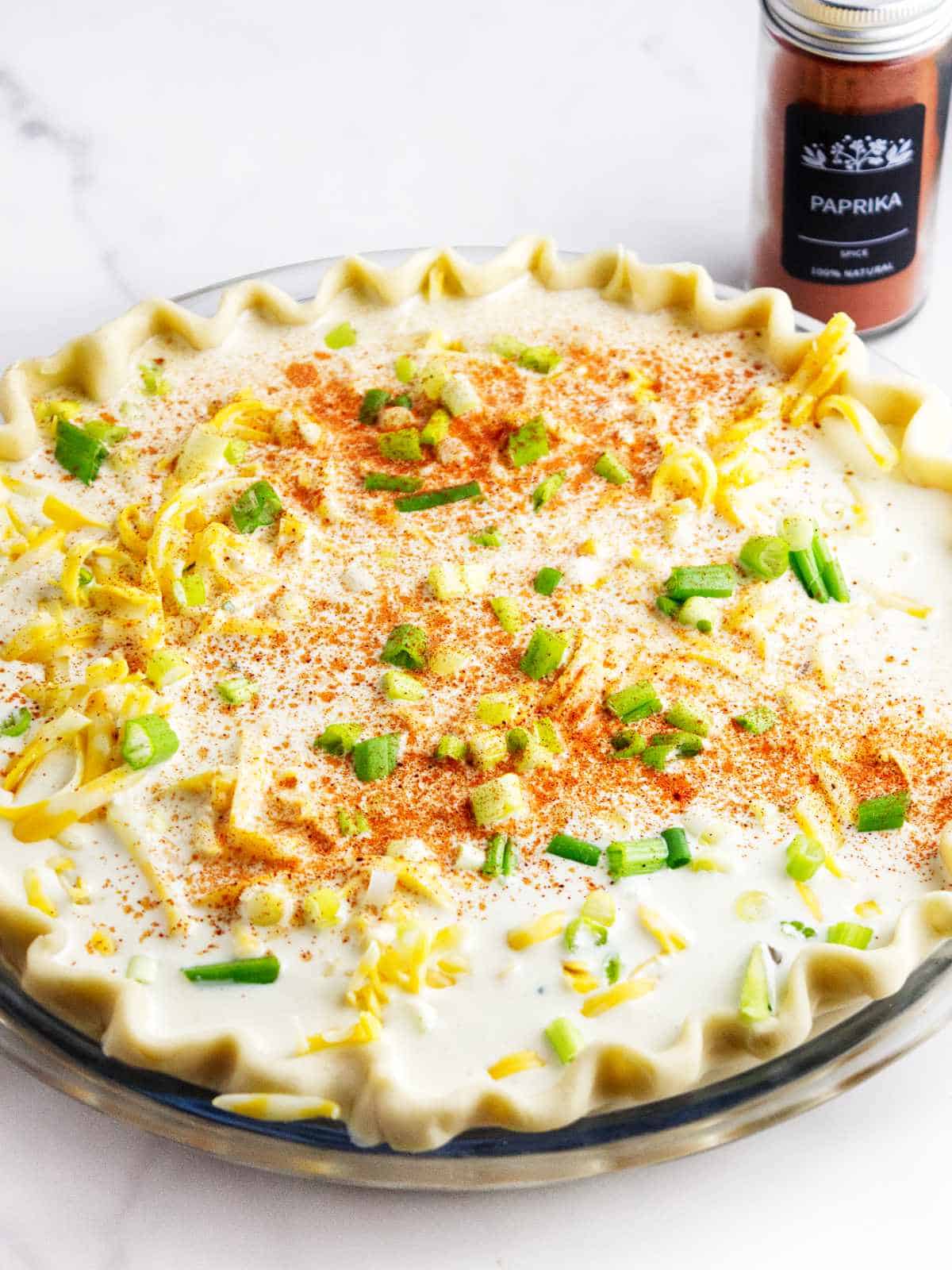seasonings and green onions sprinkled on top of a pie.