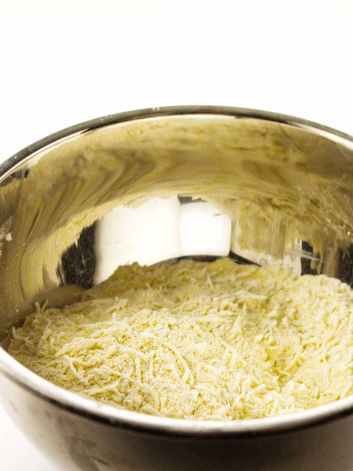 toss the grated cheese in the cornmeal and flour mixture.