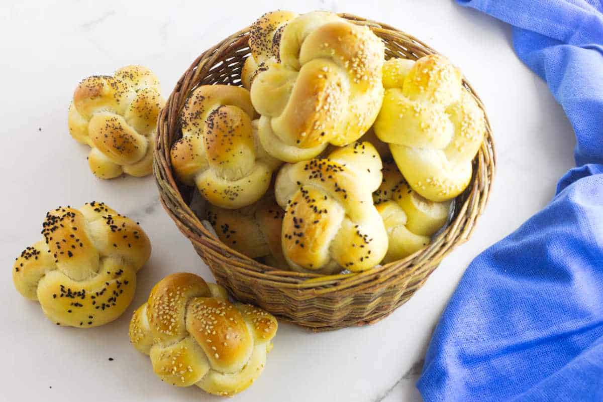 challah rolls in a basket with a white background.