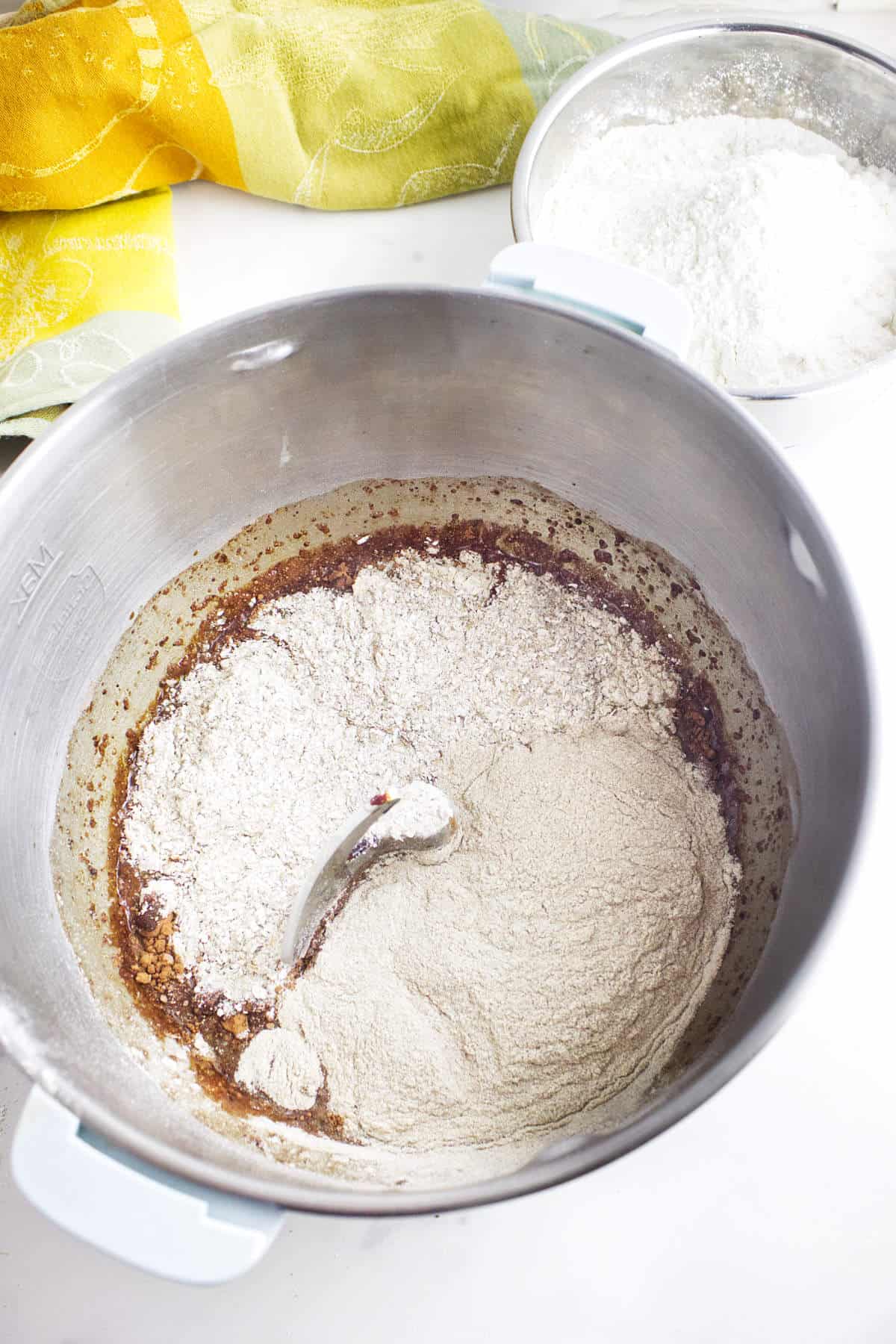 Rye flours and bread flour being added to brown bread roll dough.