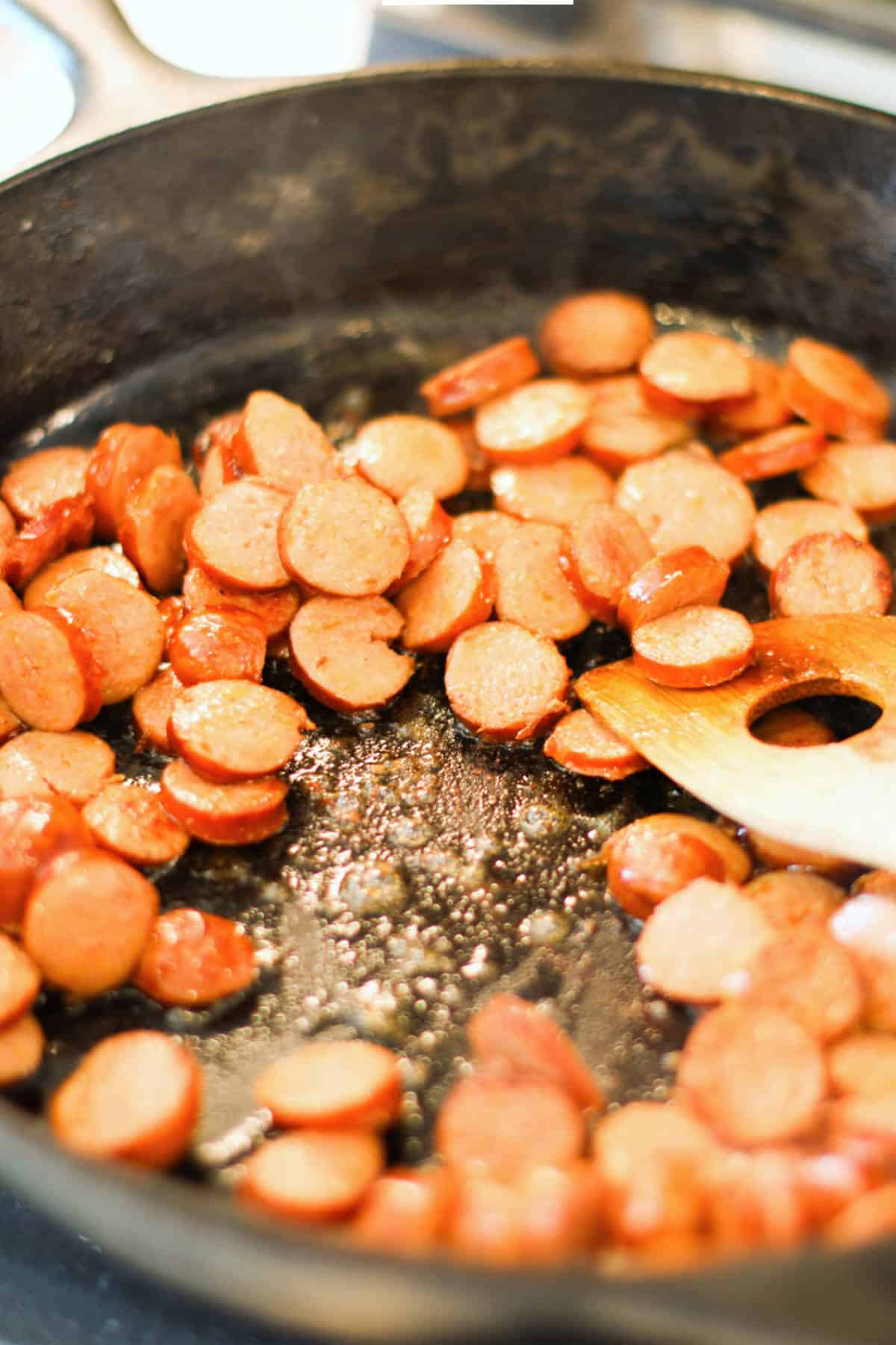 fried sausage coins in a cast iron skillet.