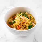 Bowl of chicken fideo soup garnished with cilantro and cotija cheese.