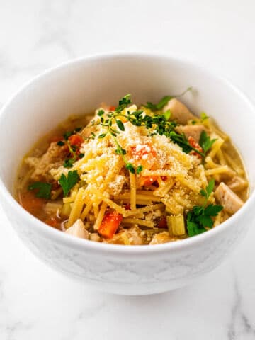 Bowl of chicken fideo soup garnished with cilantro and cotija cheese.