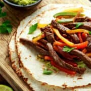 Chili's steak fajitas copycat with sliced steak, peppers, onions, and tortillas.
