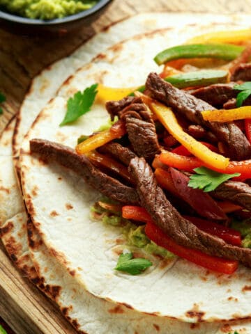 Chili's steak fajitas copycat with sliced steak, peppers, onions, and tortillas.