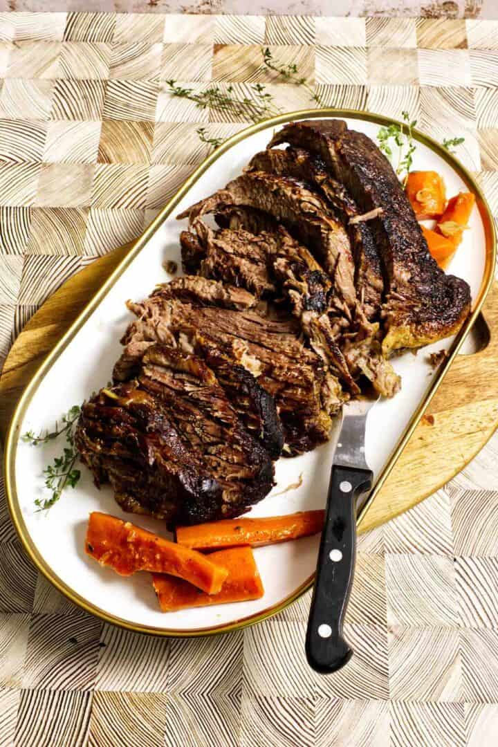 A plate of cider braised beef brisket served with tender cooked vegetables.