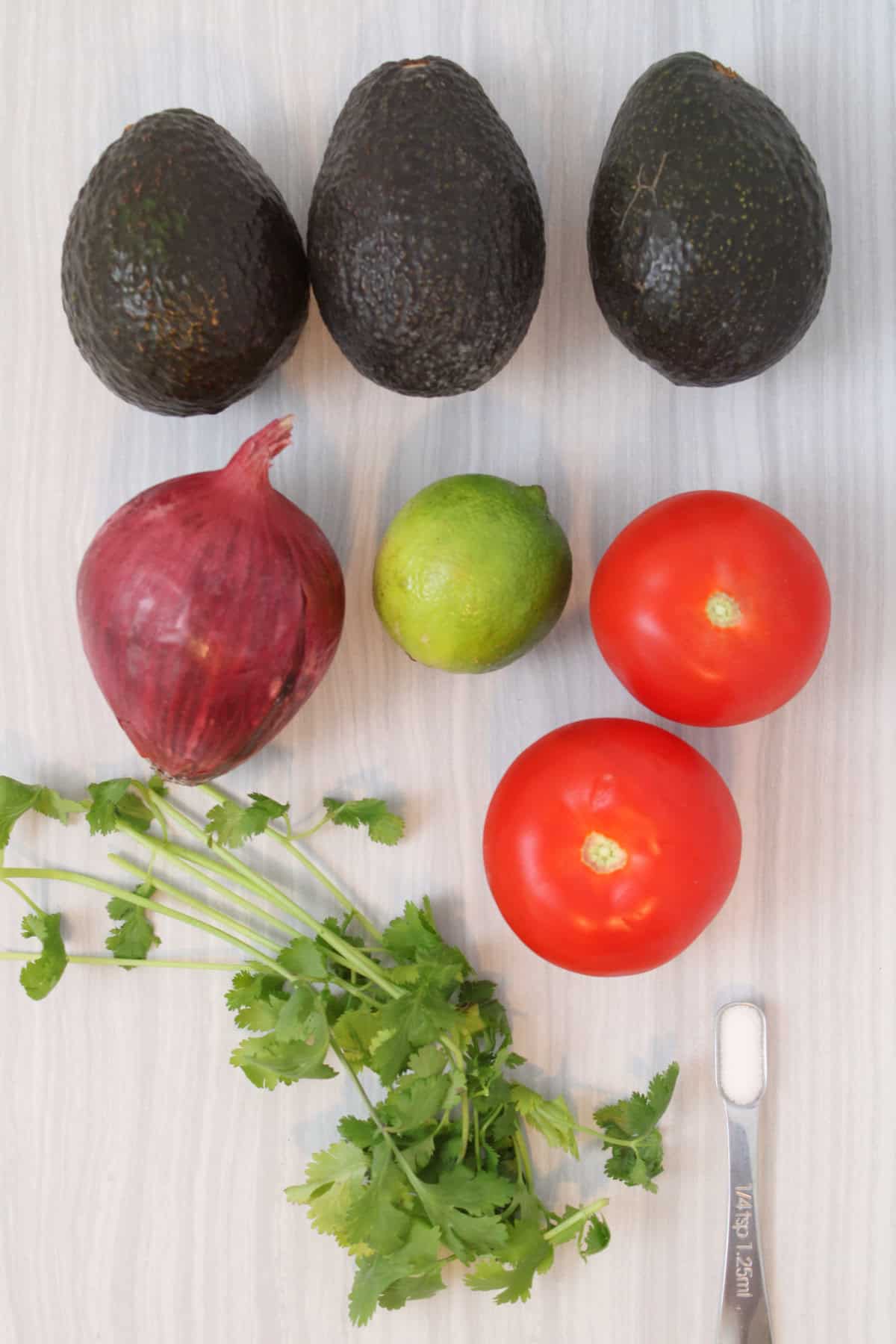 Avocados, tomato, red onion, lime, salt, and cilantro for homemade guacamole.