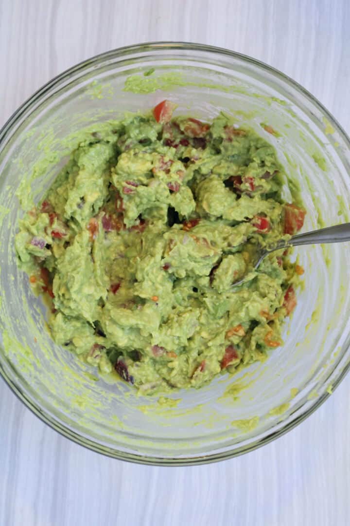 Guacamole mixed with onion, tomato, cilantro, lime juice, and salt.